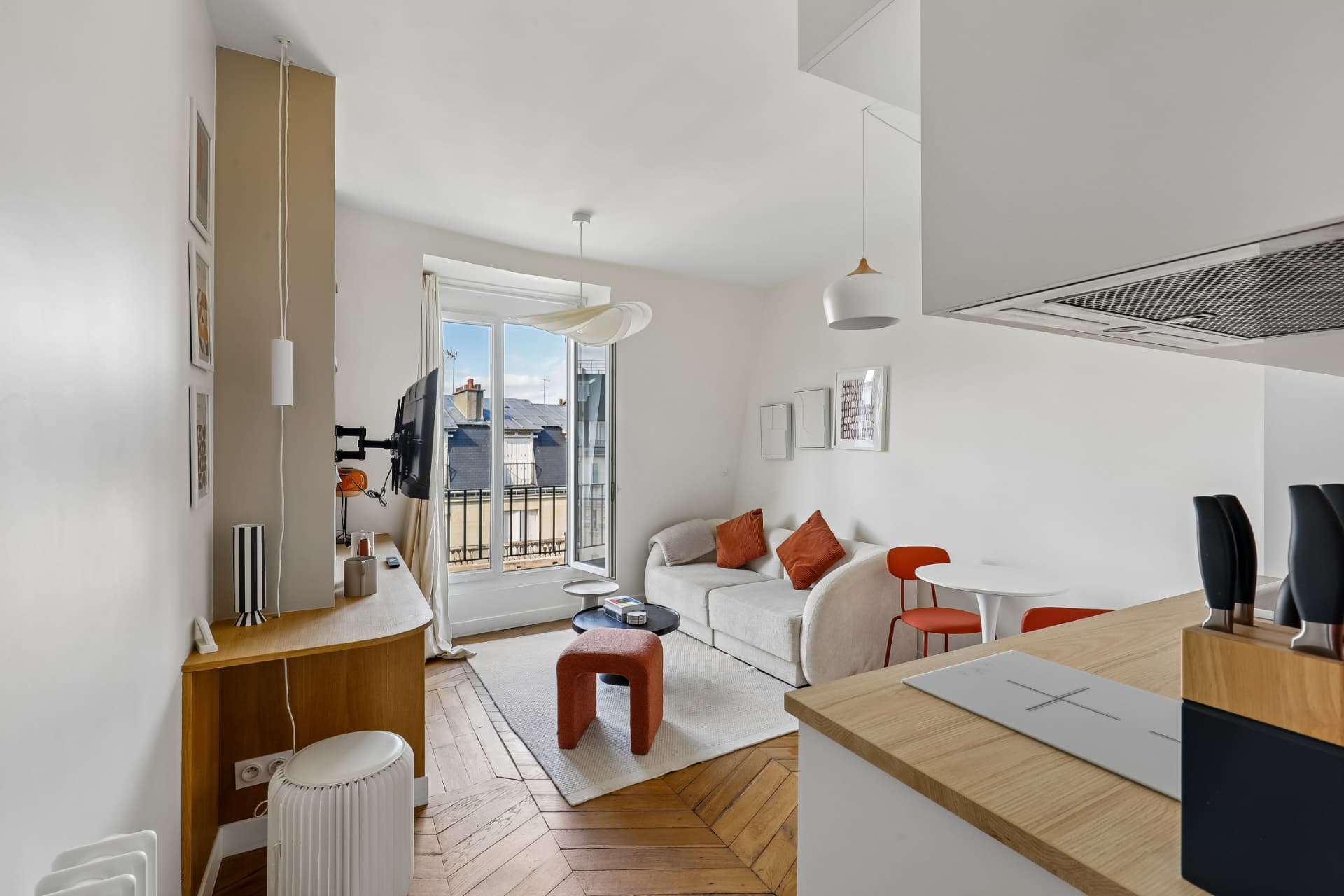 Séjour du lot 20 avec cuisine ouverte, télévision et porte-fenêtre donnant sur le balcon