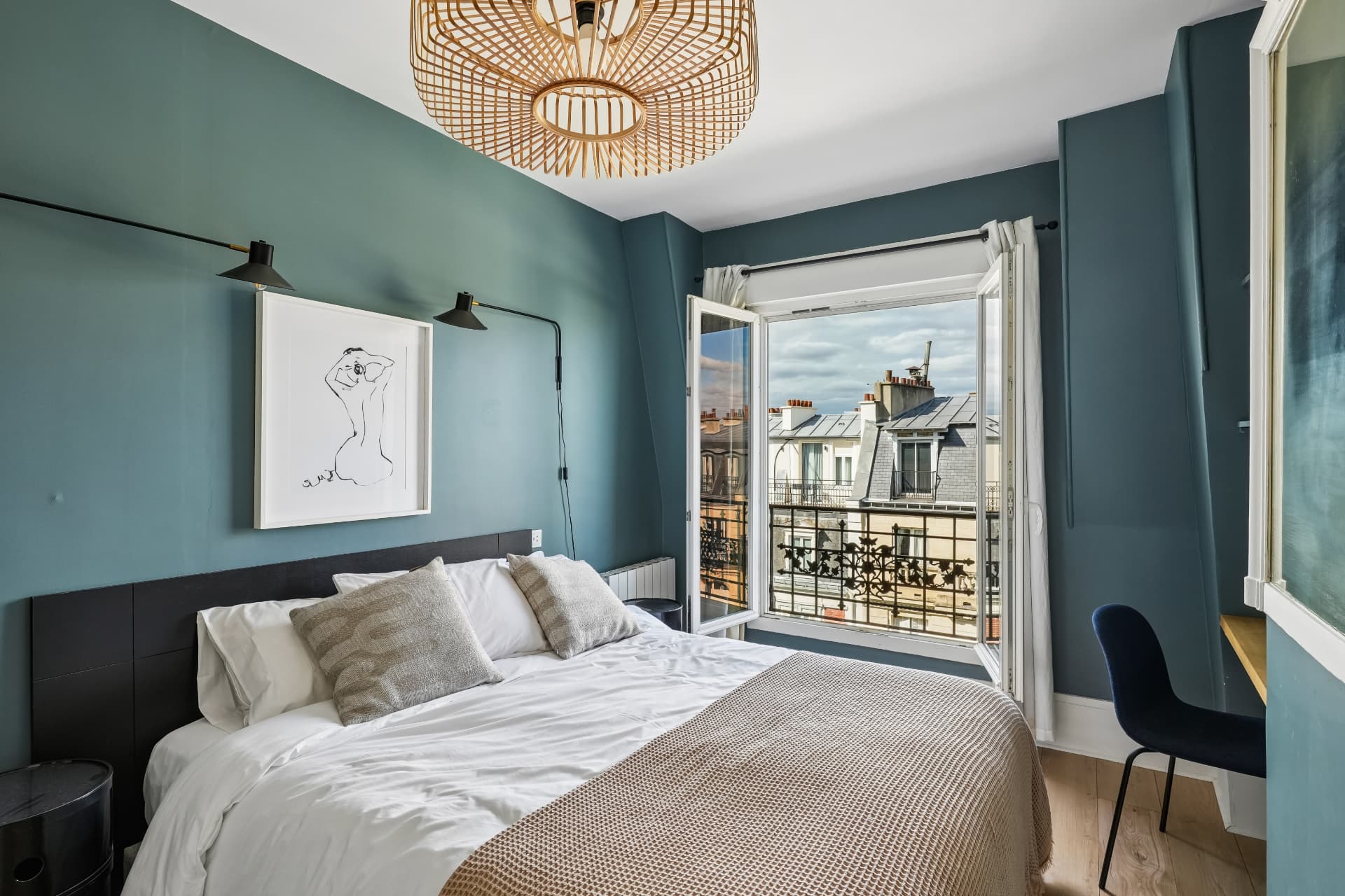 Chambre du lot 19 sous les combles, appliques noires et porte-fenêtre ouverte sur les toits