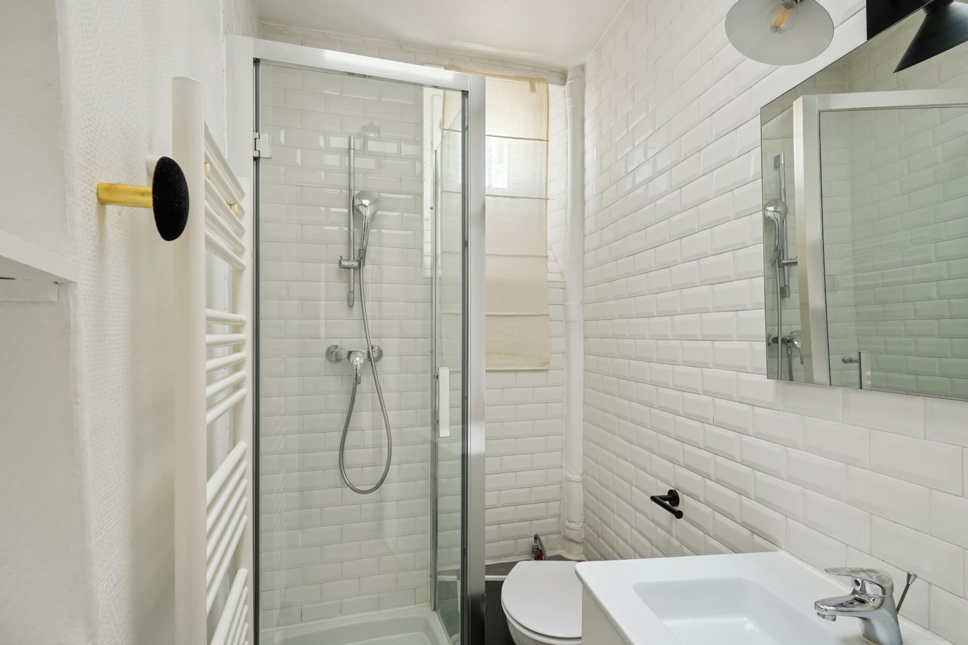 Salle d'eau du lot 19 carrelée de métro blanc avec douche vitrée et meuble vasque