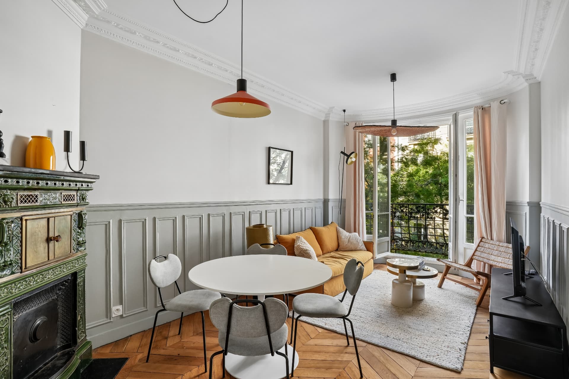 Séjour du lot 10 avec suspension orange, canapé jaune et porte-fenêtre sur balcon