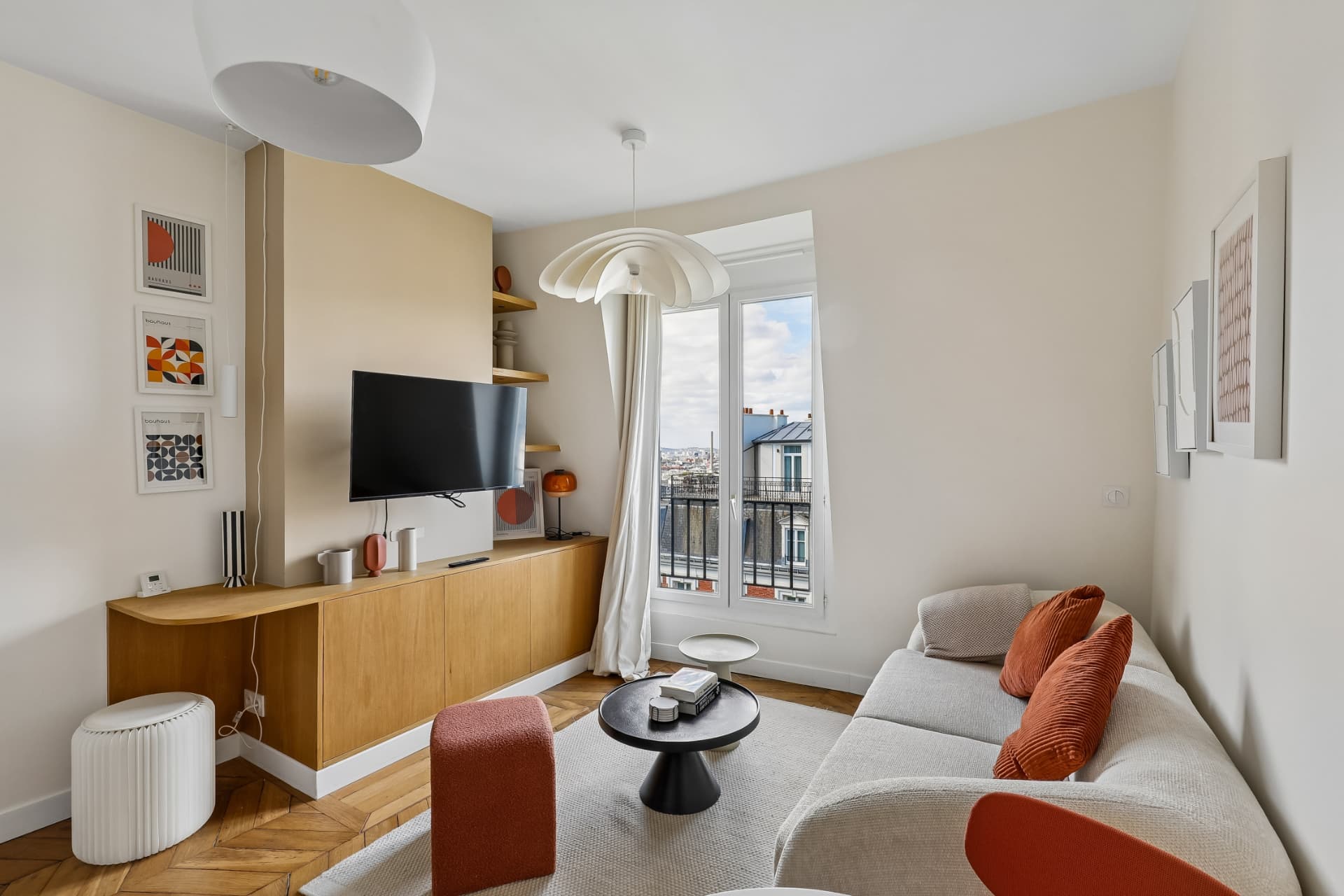 Séjour du lot 20 avec bureau en bois, télévision et vue sur le balcon