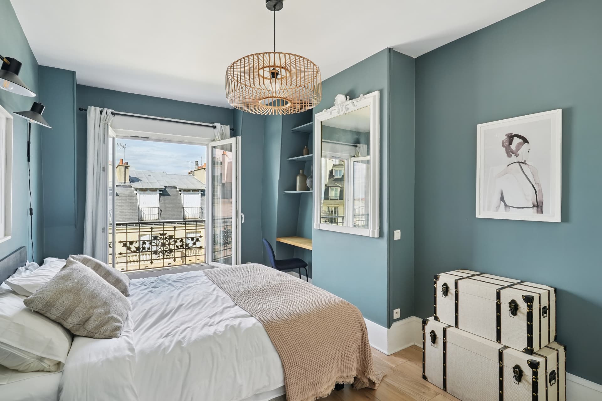 Chambre du lot 19 aux murs vert-de-gris, suspension en rotin et balcon filant