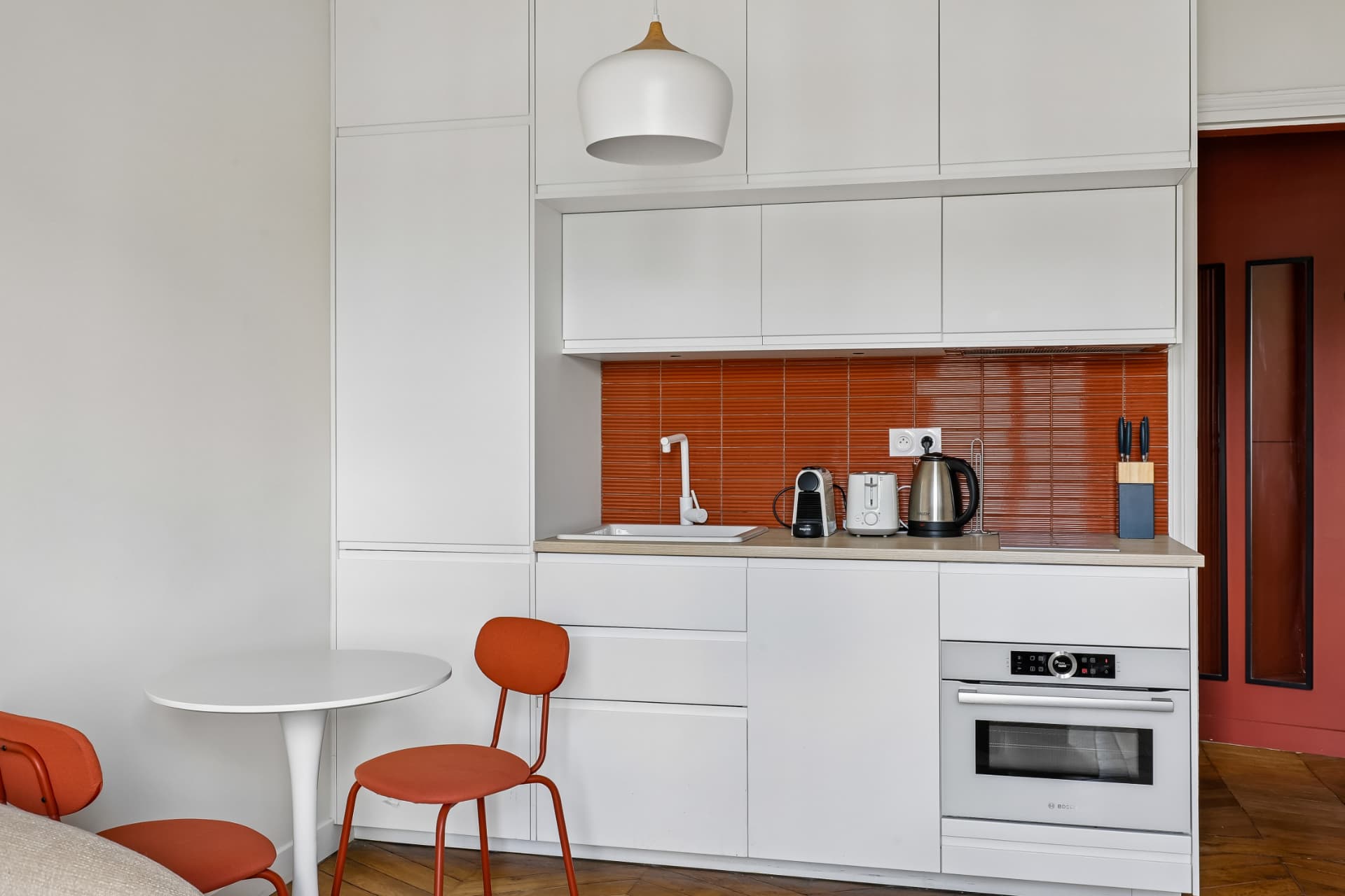 Cuisine du lot 20, crédence orange en carrelage, four encastré et plan de travail
